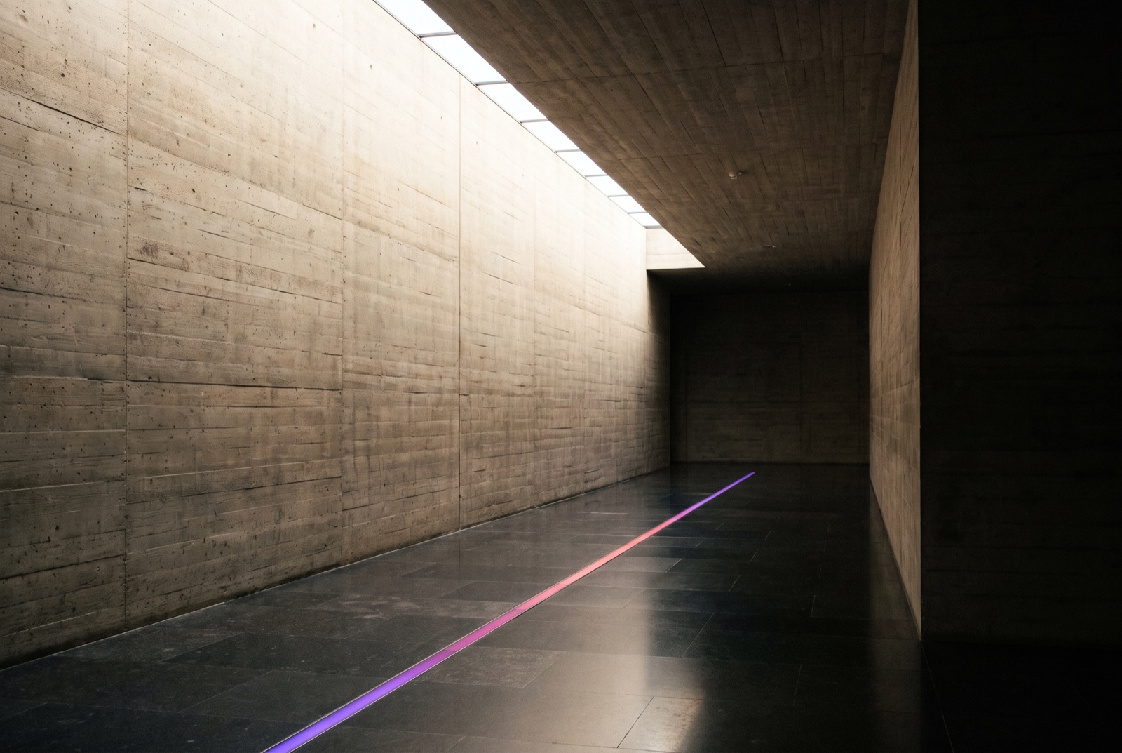 Pasillo de hormigón con una línea de luz en el suelo